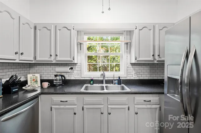 a kitchen with granite countertop a stove a sink and cabinets