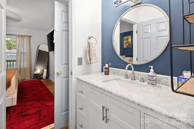a bathroom with a granite countertop sink and a mirror