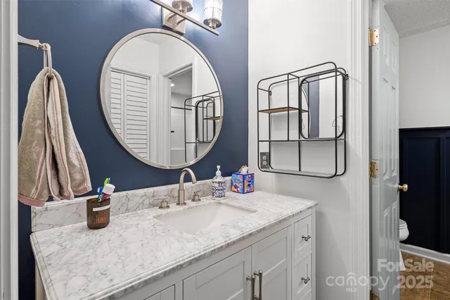 a bathroom with a sink a toilet and a mirror