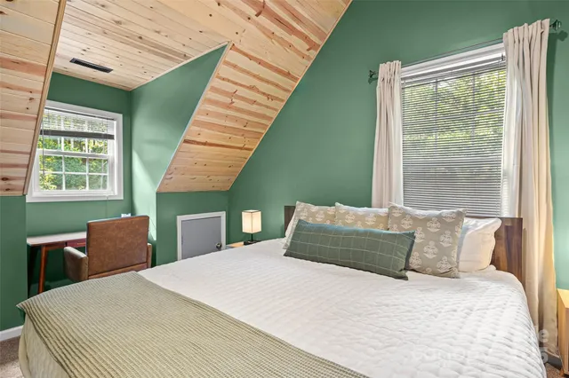 a bedroom with a bed and windows