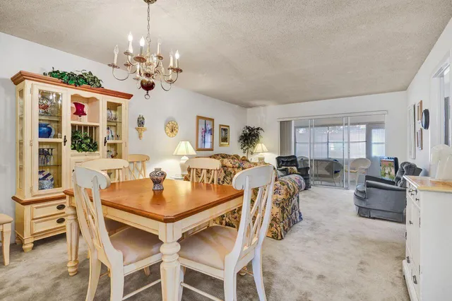 a view of a dining room with furniture a chandelier and window