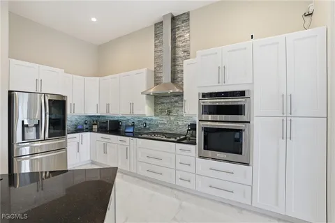 a view of a livingroom with a flat screen tv a ceiling fan and a kitchen view