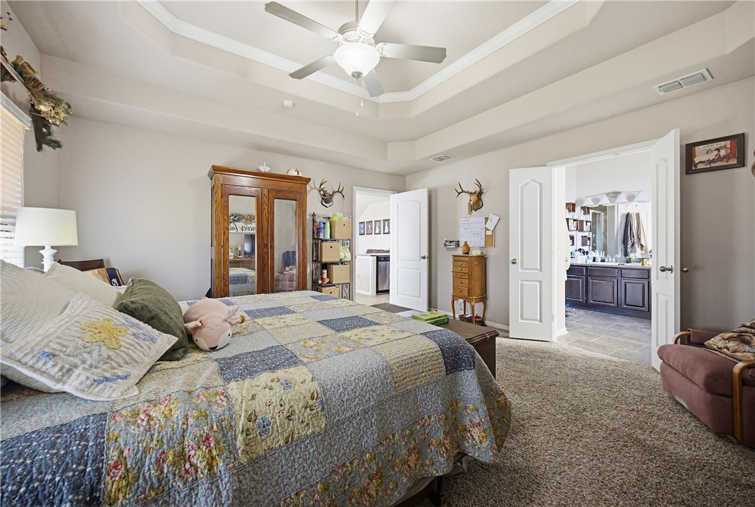 2129 Escondido Street Portland, TX 78374 - Photo 14 of 29 a spacious bedroom with a bed and a chandelier