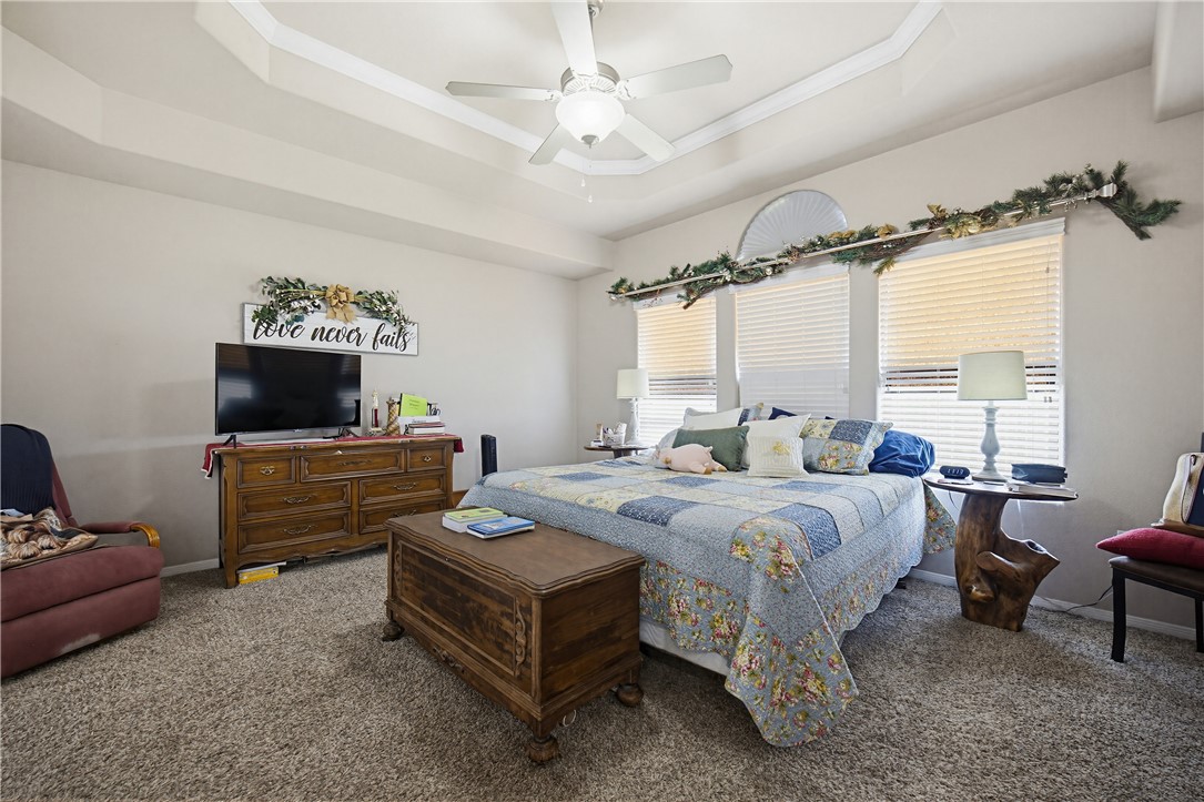 2129 Escondido Street Portland, TX 78374 - Photo 15 of 29 a spacious bedroom with a bed a couch and a window