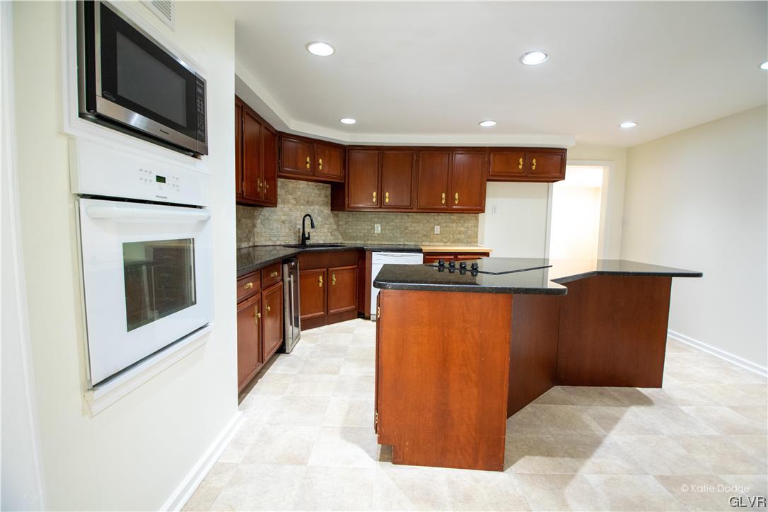 395 Buttermilk Road Easton, PA 18042 - Photo 8 of 41 a kitchen with stainless steel appliances granite countertop a stove top oven a sink and a microwave