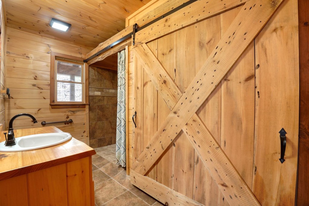 158 Whispering Pines Blue Ridge, GA 30513 - Photo 27 of 74 a bathroom with a sink a mirror and a shower