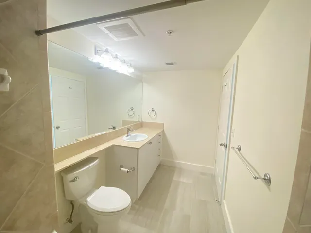 a bathroom with a granite countertop sink toilet and shower