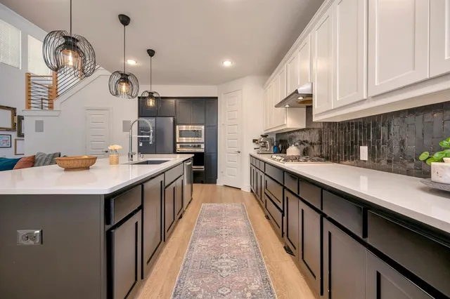 a kitchen with stainless steel appliances a sink and a refrigerator
