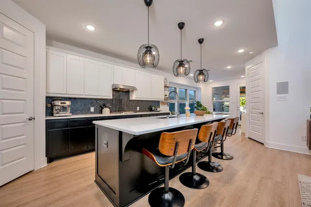 a kitchen with a sink a counter space appliances and cabinets
