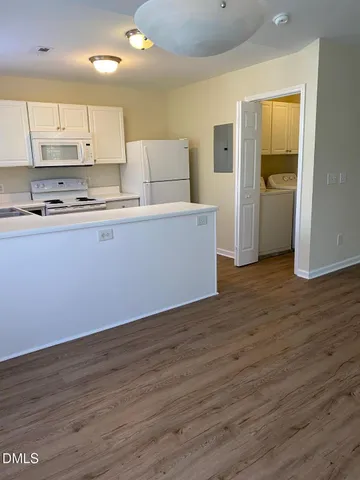 a living room with stainless steel appliances granite countertop a refrigerator and a stove top oven