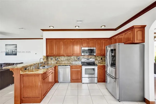 a kitchen with stainless steel appliances granite countertop a refrigerator stove top oven and sink