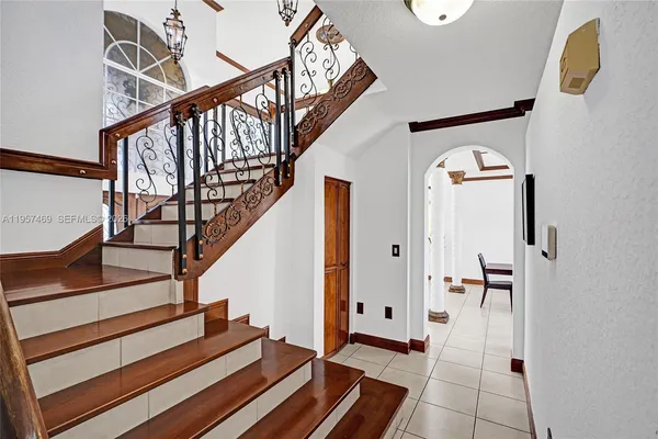 a view of staircase with railing and a chandelier