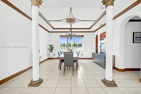 a dining room with glass top table and chairs