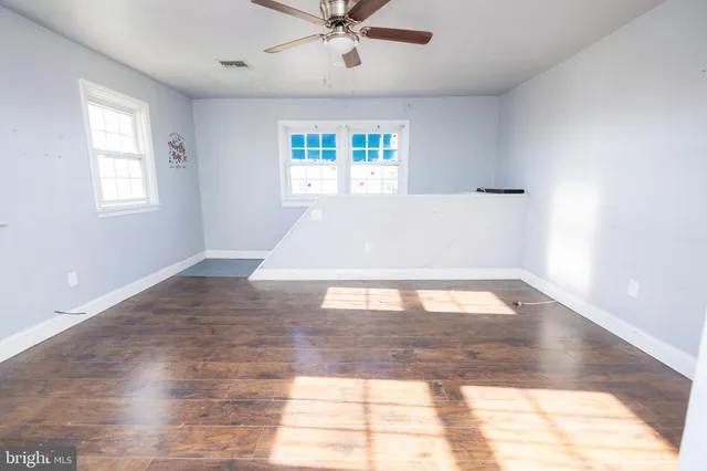 a view of an empty room with wooden floor