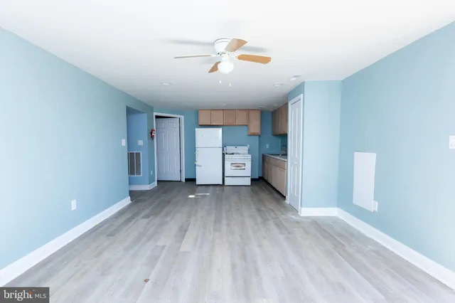 a kitchen with white cabinets white appliances and sink