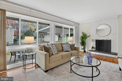 a living room with furniture a fireplace a flat screen tv and a large window