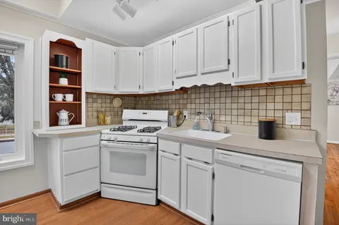 a kitchen with white cabinets and white appliances