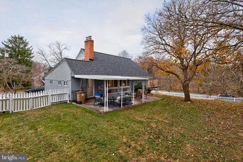 a view of a house with backyard and a tree