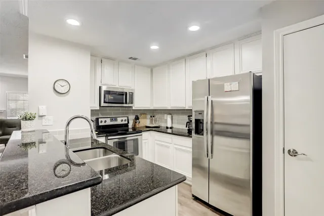 a kitchen with granite countertop a stove and a microwave