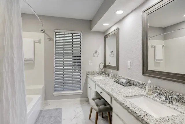 a bathroom with a granite countertop sink double and mirror