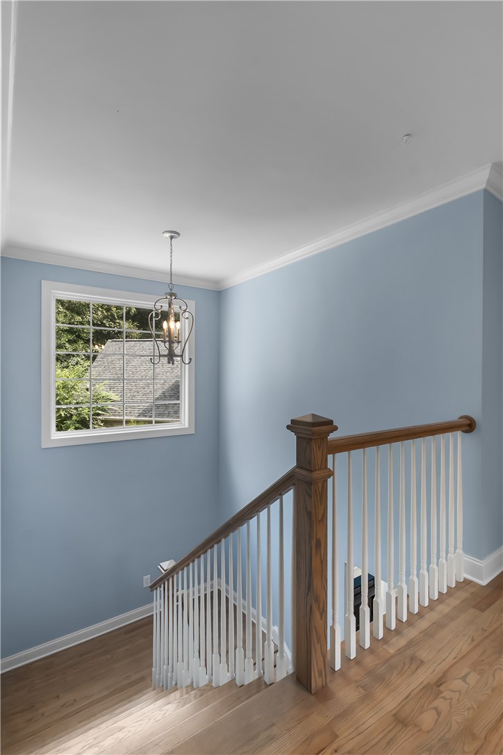 206 Village Way Pendleton, SC 29670 - Photo 21 of 46 A well-lit stairwell features hardwood flooring, elegant crown molding, and a charming chandelier.
