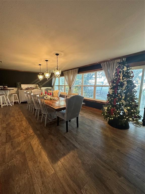 101 Twin Creek Road Comanche, TX 76442 - Photo 18 of 28 Dining room with a textured ceiling, dark wood-style floors, and a chandelier