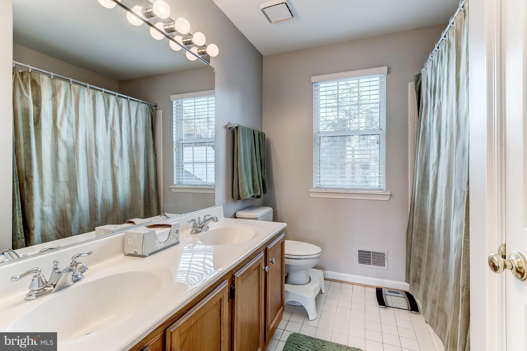 4313 Mispillion Road Baltimore, MD 21236 - Photo 22 of 38 a bathroom with a granite countertop sink toilet and large mirror