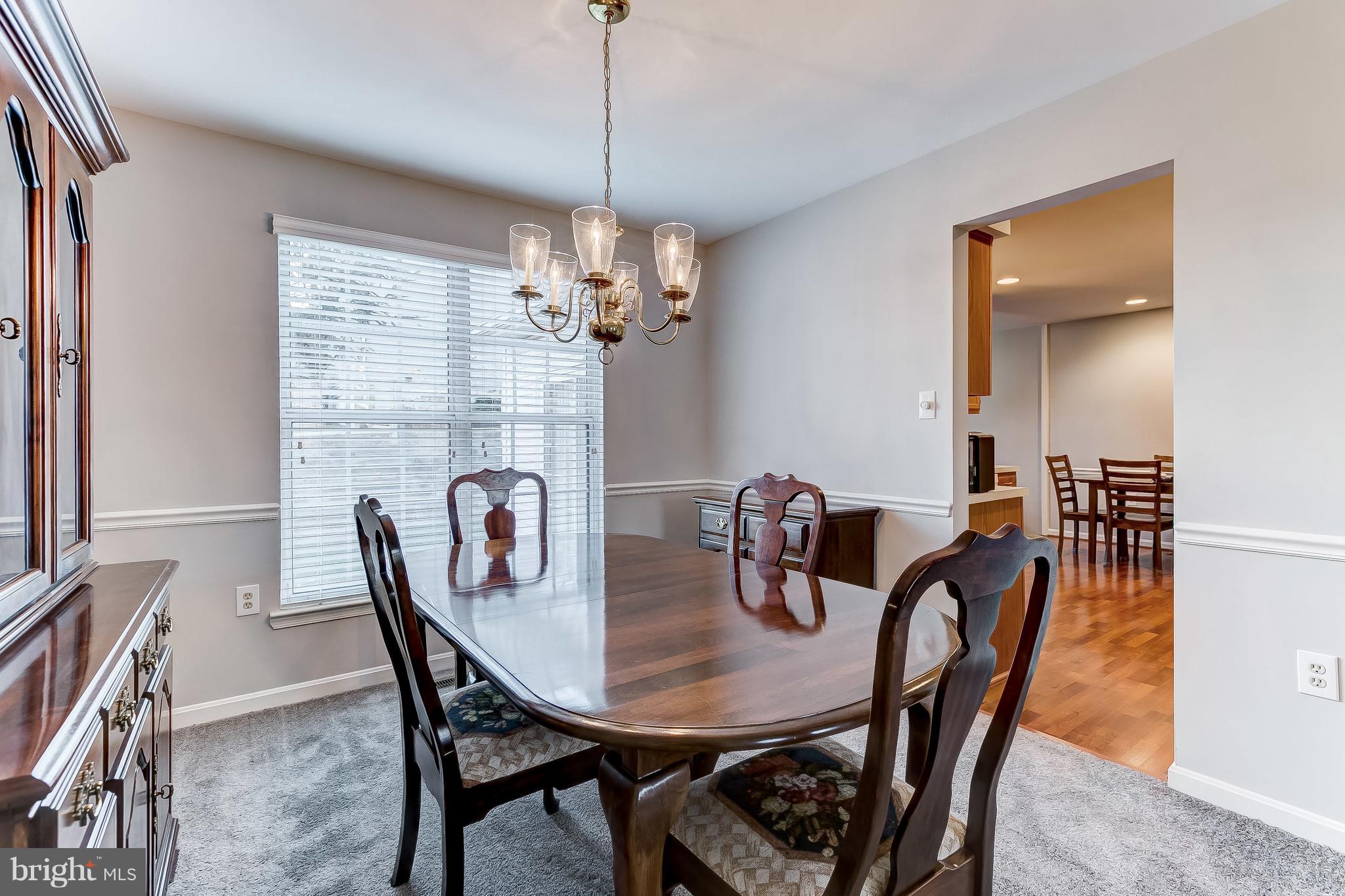 4313 Mispillion Road Baltimore, MD 21236 - Photo 8 of 38 a view of a dining room with furniture a chandelier and wooden floor