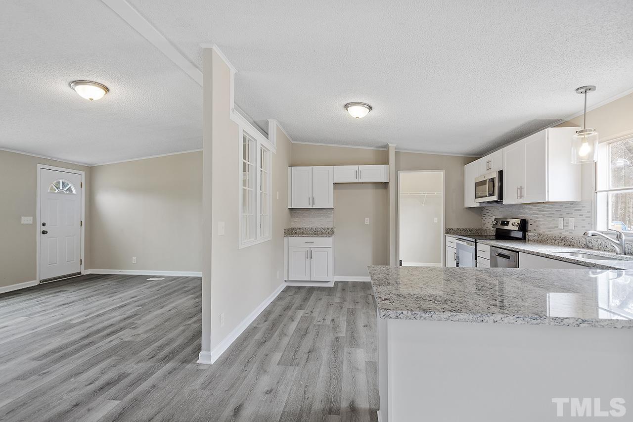 671 Providence Road Roxboro, NC 27573 - Photo 13 of 39 a kitchen with granite countertop a refrigerator and a sink