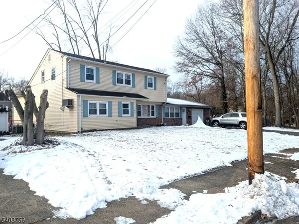 a front view of a house with a yard covered in snow