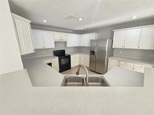 a kitchen with a sink a counter top space stainless steel appliances and cabinets
