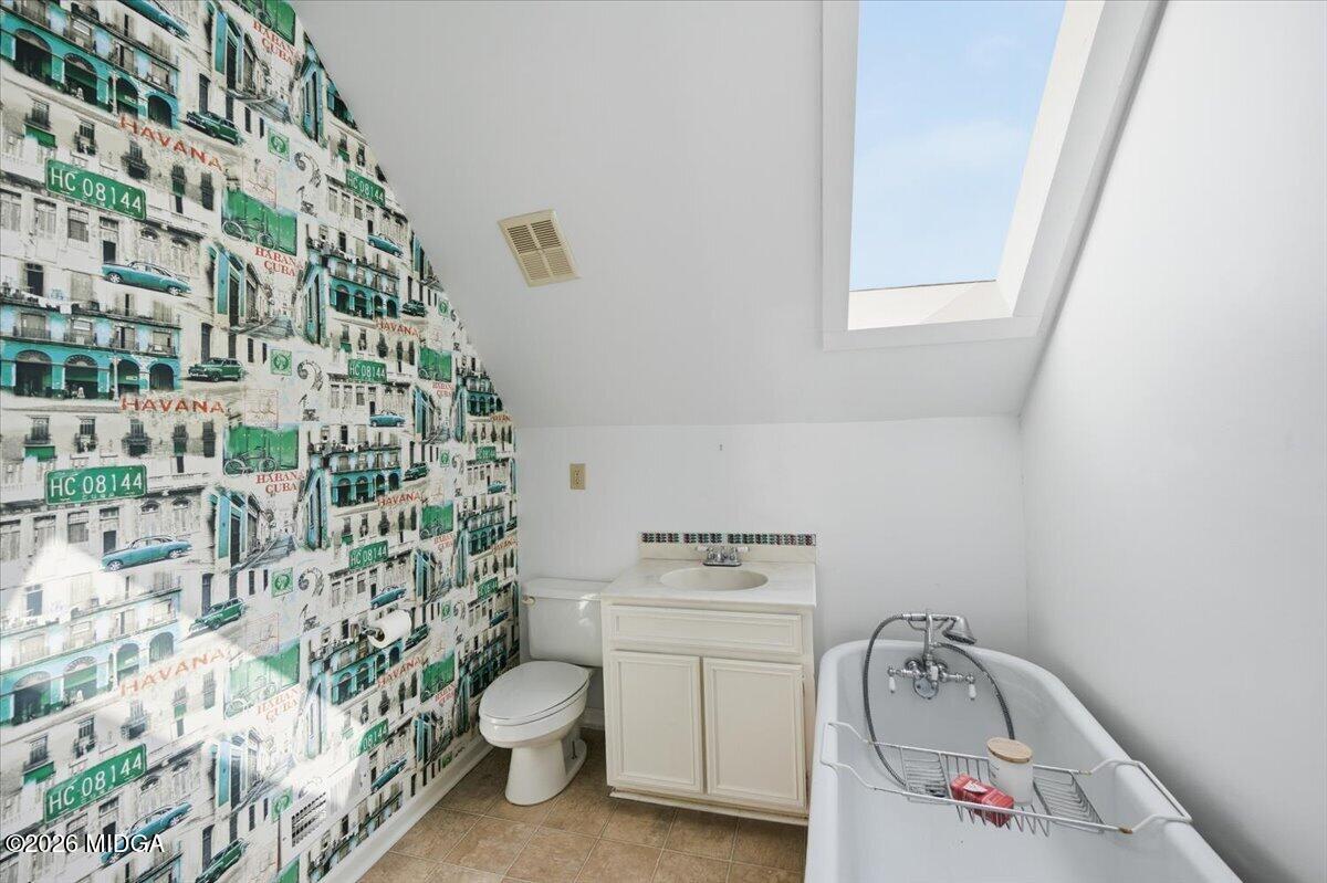 1019 Bond Street Macon, GA 31201 - Photo 18 of 56 a bathroom with a toilet and shower curtain