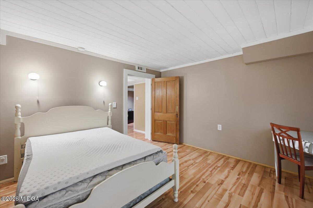 1019 Bond Street Macon, GA 31201 - Photo 35 of 56 a bedroom with a large bed and a wooden floor
