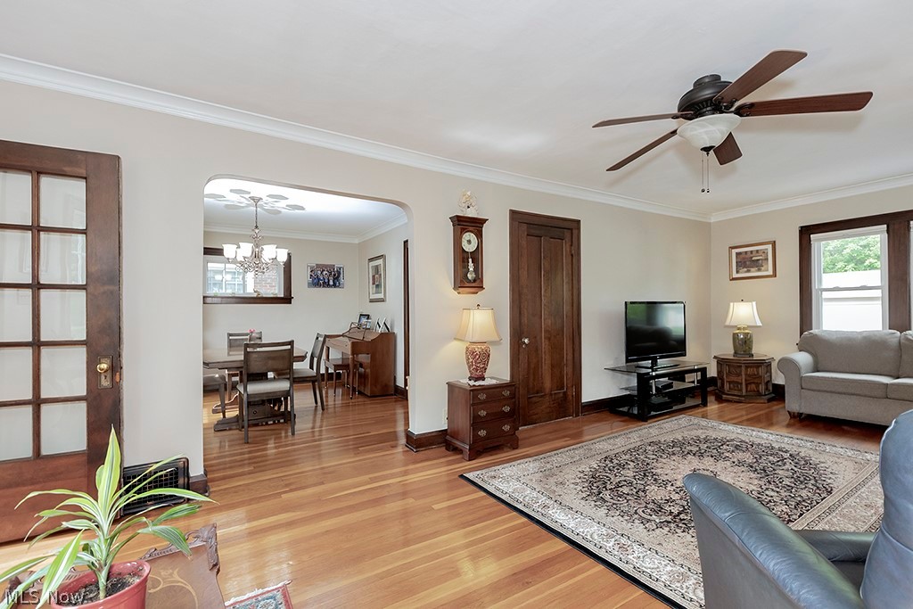 2480 Eaton Road Cleveland, OH 44118 - Photo 6 of 41 Living room featuring ornamental molding, light hardwood / wood-style flooring, and ceiling fan with notable chandelier