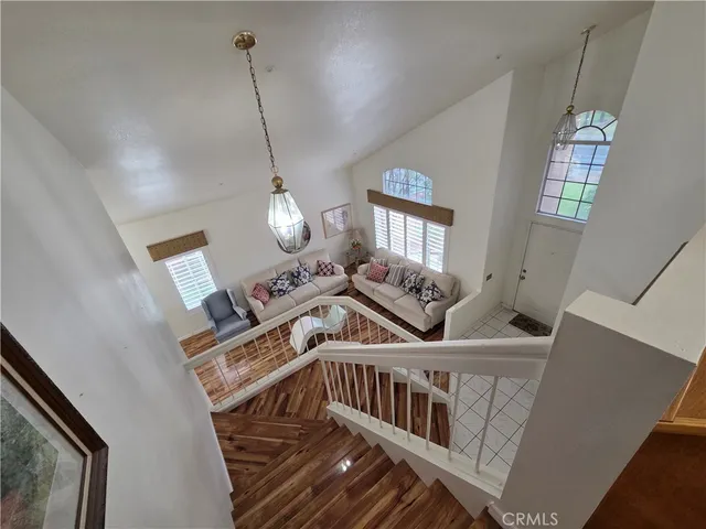 a view of an entryway wooden floor and chandelier