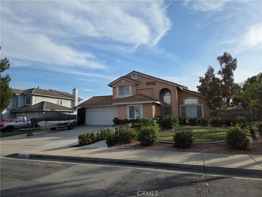 1669 West Victoria Street Rialto, CA 92376 - Photo 2 of 22 a front view of a house with a garden