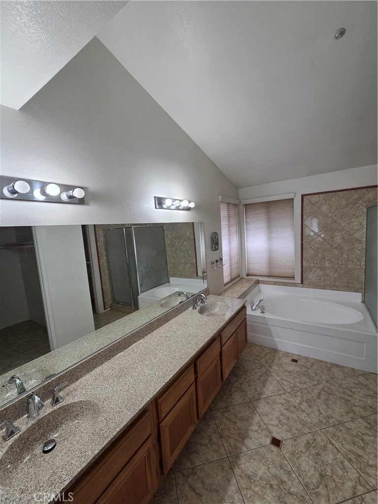 1669 West Victoria Street Rialto, CA 92376 - Photo 7 of 22 a bathroom with a granite countertop double vanity sink a bathtub and mirror
