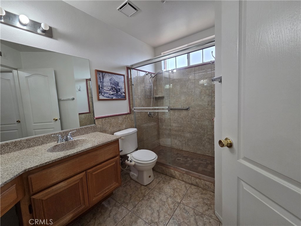 1669 West Victoria Street Rialto, CA 92376 - Photo 9 of 22 a bathroom with a granite countertop sink toilet and shower