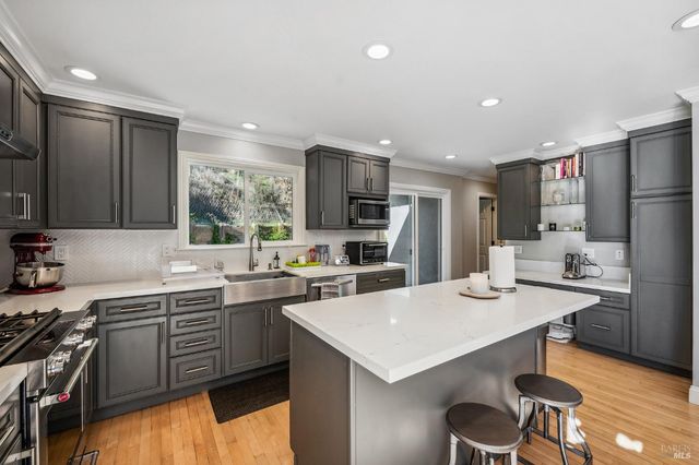 a kitchen with a sink a stove a refrigerator and chairs