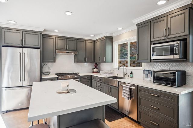 a kitchen with a sink a stove a microwave and refrigerator