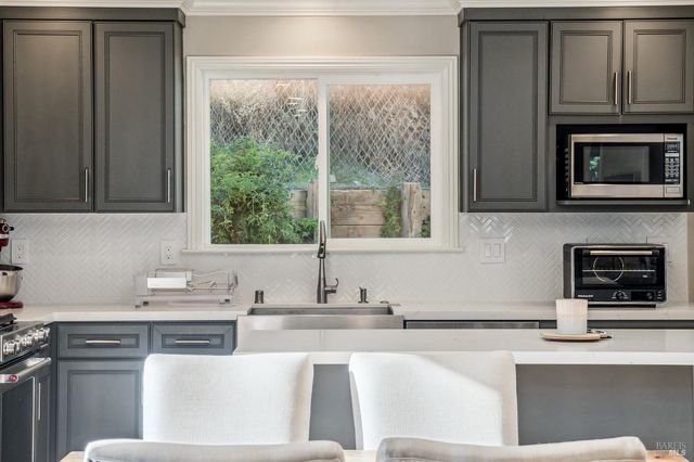 a kitchen with stainless steel appliances granite countertop a sink and a microwave