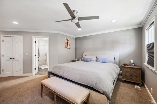 a bedroom with a bed and a ceiling fan