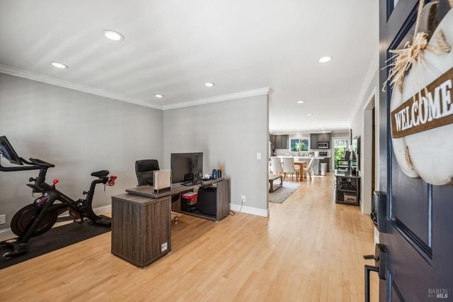 a living room with furniture a flat screen tv and a wooden floor
