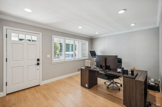a view of a workspace with furniture and a window