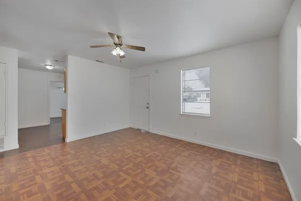 an empty room with fan and windows