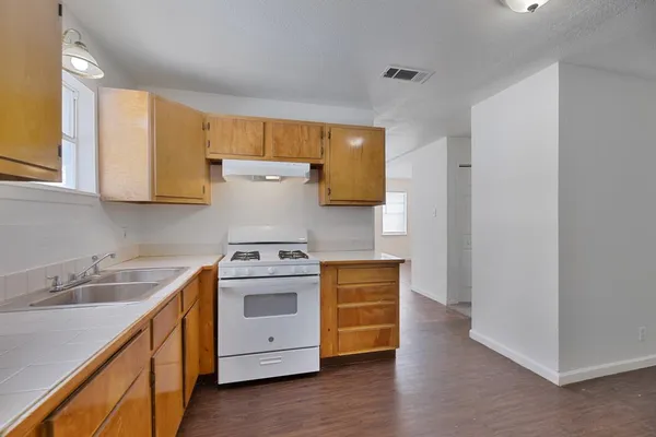 a kitchen with a sink a stove and cabinets