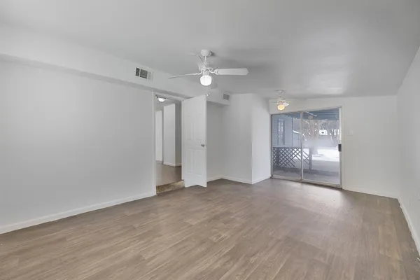 a view of empty room with wooden floor