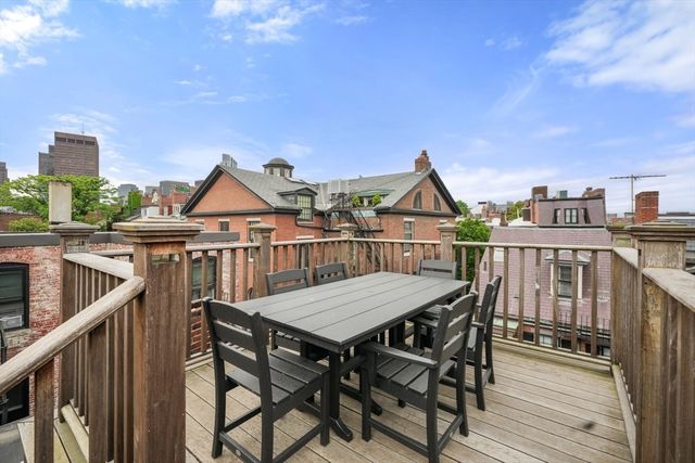 a view of a roof deck with table and chairs