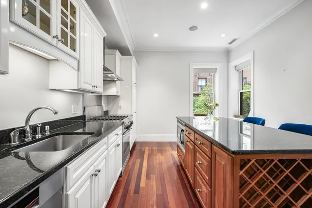 a kitchen with stainless steel appliances granite countertop a sink stove and cabinets