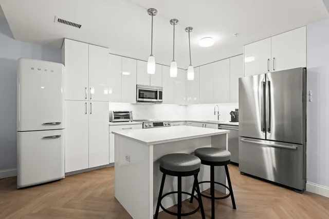 a kitchen with stainless steel appliances a refrigerator a stove a sink and white appliances